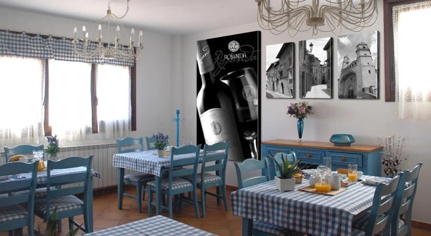 Comedor del desayuno con mesas de manteles de cuadros y sillas azules