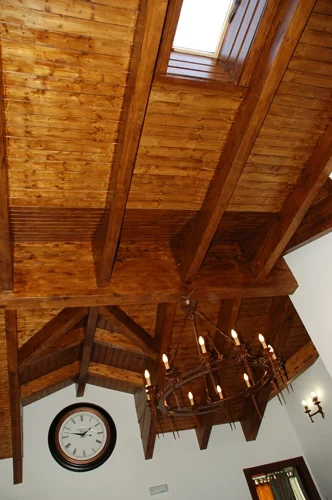 Techo de vigas de madera con lucernario, lámpara de hierro y reloj